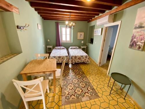 加的斯西班牙膳食公寓的一间设有两张床和一张桌子及椅子的房间