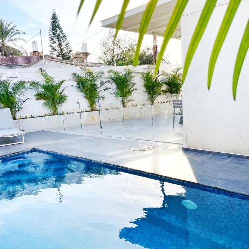 里雄莱锡安Luz Mansion ~ Lux & Comfy的棕榈树屋前的游泳池