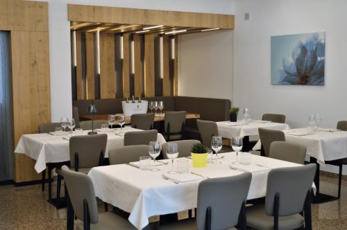 莫里瑞斯特雷特达纳尼旅馆的餐厅配有白色桌椅和酒杯