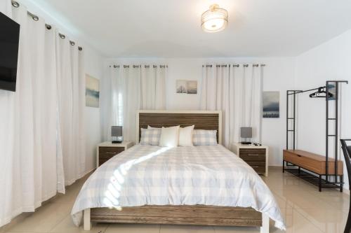 多拉多Aquaville Dorado Moderna Studio 6的卧室配有一张带白色窗帘的大床