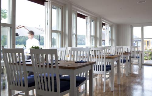 Stegeborg斯特格伯格花园酒店的一间设有白色椅子和桌子的用餐室以及窗户。