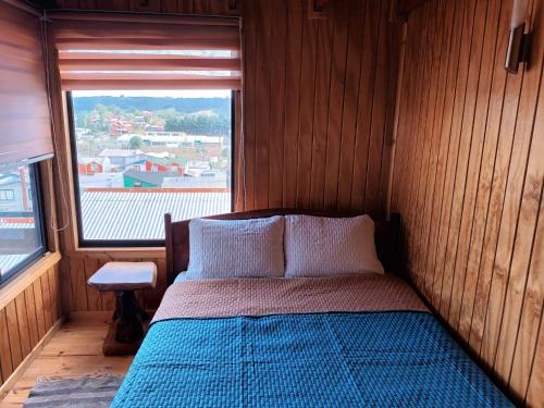 达卡卫Cabaña piedra azul的一张位于带大窗户的房间内的床铺