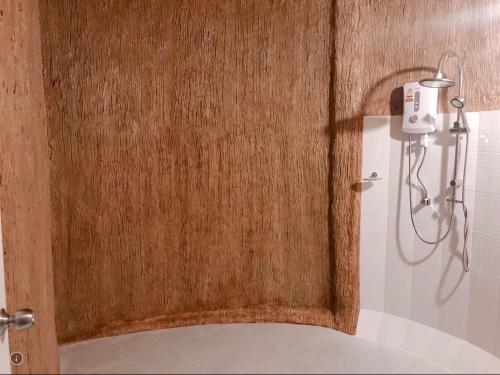 Lang SuanBan Tawansongfa的浴室设有带淋浴的木门。