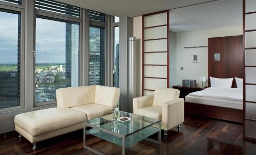 美因河畔法兰克福INNSiDE by Meliá Frankfurt Eurotheum的配有床、椅子和桌子的酒店客房