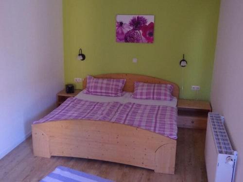 OrthFerienwohnung direkt am Hafen in Fehmarn-Orth的一间卧室配有一张带紫色床单和枕头的木床。