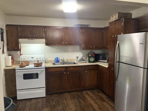 ConleyCozy Large home, 19 Min from Hartsfield-Jackson international- Domestic Airport!的厨房配有白色冰箱和木制橱柜。