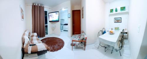 瓜拉派瑞Apartamento temporada com garagem, Wi-Fi, Netflix的白色的客房配有桌子和电视