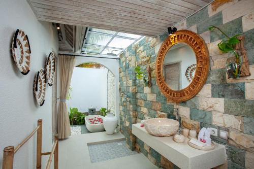 乌布Amaya Sebatu Villa的一间带镜子和石墙的浴室