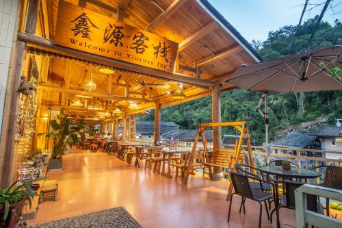 南靖县南靖土楼鑫源民宿的一间带桌椅和遮阳伞的餐厅