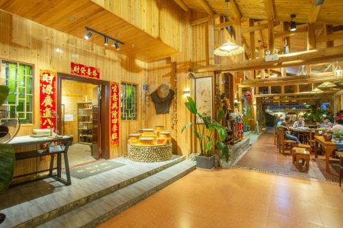 南靖县南靖土楼鑫源民宿的餐厅设有桌椅和木墙