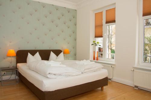汉堡施拉夫朗奇酒店的一间卧室设有一张大床和两个窗户。