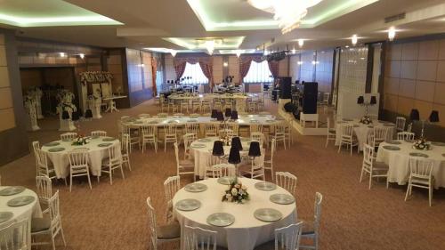 安卡拉达芙尼酒店的宴会厅配有白色的桌椅
