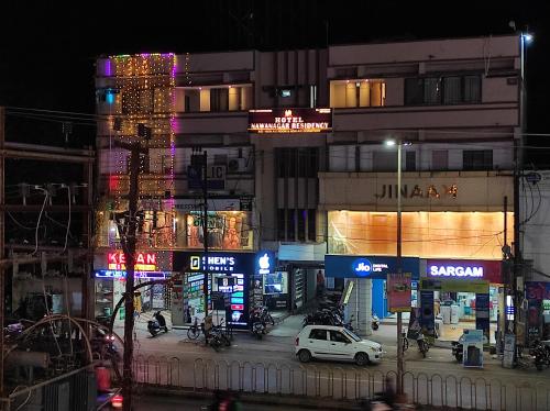 贾姆讷格尔Hotel Nawanagar Residency的街道,夜间有汽车和建筑