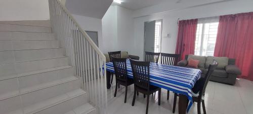 Bandar Puncak AlamHud Hud Homestay的一间配备有蓝色桌子和椅子的用餐室