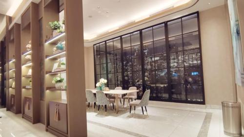 LontarBenson Tower Surabaya Apartment 2BR by Le Ciel Hospitality的一间带桌椅和大窗户的用餐室