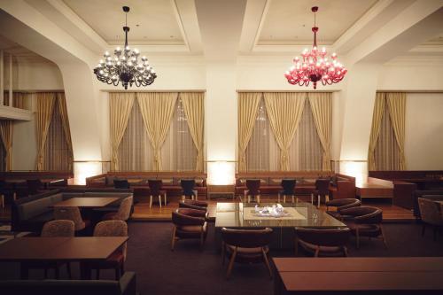 小樽OMO5 Otaru by Hoshino Resorts的餐厅设有桌椅和吊灯。