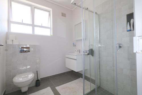 梅森堡Royal House的一间带卫生间和玻璃淋浴间的浴室
