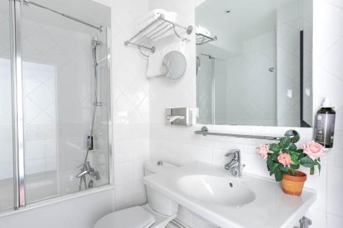 巴黎柯马丁歌剧院阿斯托利亚酒店的白色的浴室设有卫生间和水槽。
