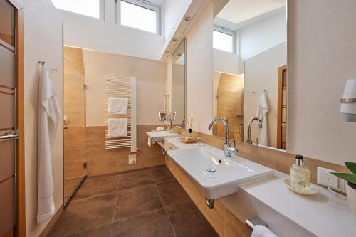施马伦贝格戴曼酒店的一间带两个盥洗盆和大镜子的浴室