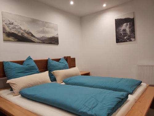 因斯布鲁克Penthouse-Feeling MaBeA的一张床上有蓝色枕头的睡床