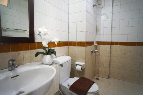 芭堤雅市中心Baan Chuan Chom Pattaya的浴室设有卫生间和花瓶水槽。