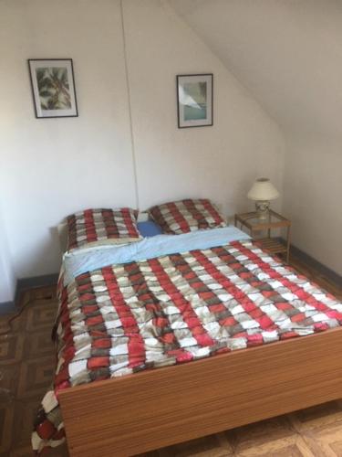 HarnesCHAMBRE D 'HOTE的一间卧室配有一张带红白色棉被的床