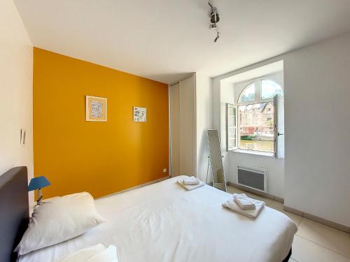 迪南金费尔濠波尔德朗塞公寓的卧室配有白色的床和橙色的墙壁