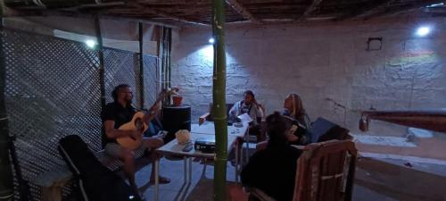 明德卢Hostel Mindelo的一群人坐在一个房间里,拿着乐器