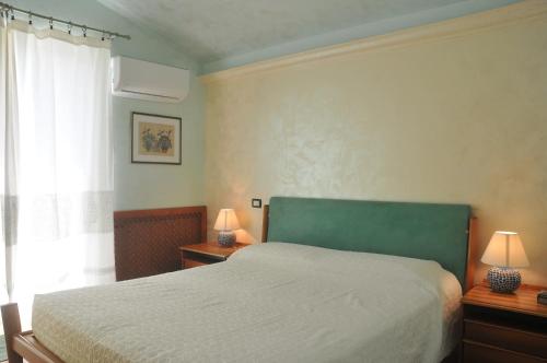 巴里萨尔多Villa Lanthana, 2 storeys, detached的一间卧室配有一张床、两盏灯和一个窗户。