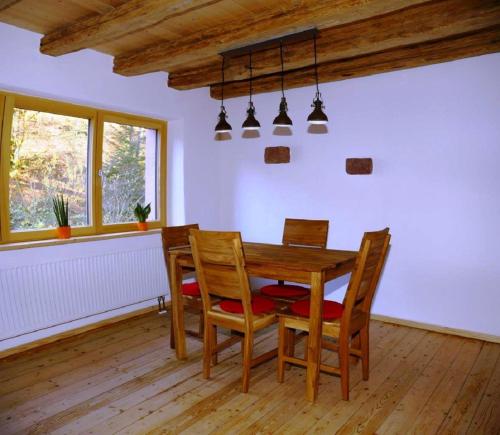 ElmsteinFerienhaus In der Erlebach的一间带木桌和椅子的用餐室