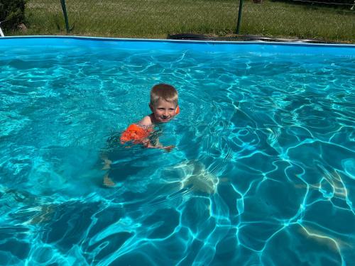HohenbollentinLandhaus mit Pool, Bungalow in der Natur的在一个游泳池游泳的男孩