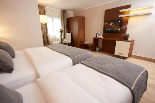 伊兹密尔Mira Otel Alsancak的酒店客房配有两张床和一张书桌