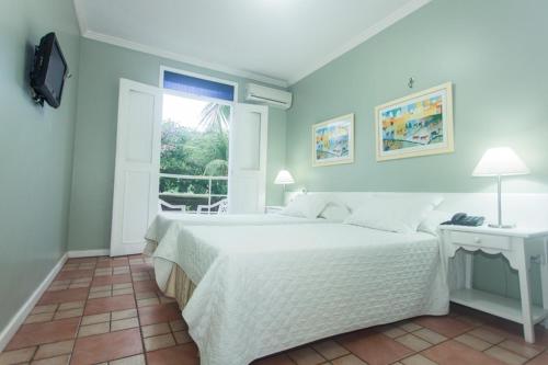 纳塔尔贝洛奥里藏特酒店的卧室配有白色的床和窗户。