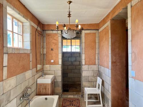 鲁亨盖里La Locanda的带浴缸、水槽和椅子的浴室