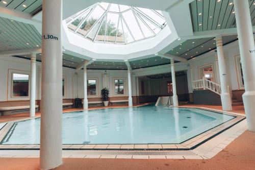贝塞尔Hotel MeerZeiten inklusive externer Schwimmbad- & Saunanutzung的一座带天窗的建筑中的游泳池