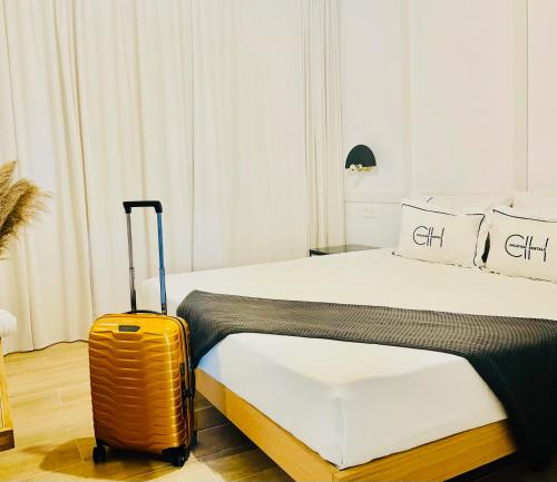卡门港CIH Apartments的酒店客房,带一张床和行李箱