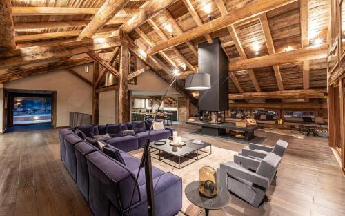 马尼戈Lodge Les Murailles的客厅配有紫色家具和木制天花板