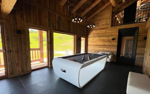 马尼戈Lodge Les Murailles的一间大型客房,在木板房里设有浴缸