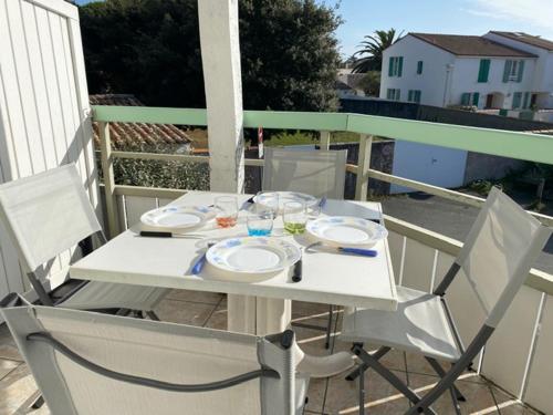 滨海拉库阿尔德Appartement en duplex avec balcon, 5 minutes plage et centre village的阳台上配有白色的桌椅