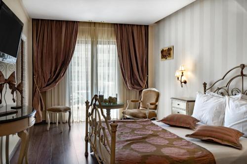 奥林匹亚基·阿克蒂Danai Hotel & Spa的卧室配有床、椅子和窗户。