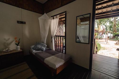 刁曼岛Swiss Cottage Tioman的客房设有窗户和一张床