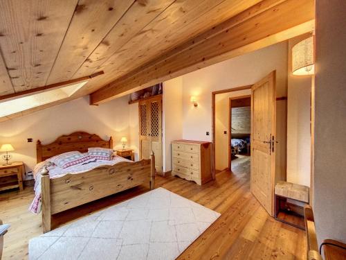 夏蒙尼-勃朗峰Bells Lodge的一间卧室设有一张床和木制天花板