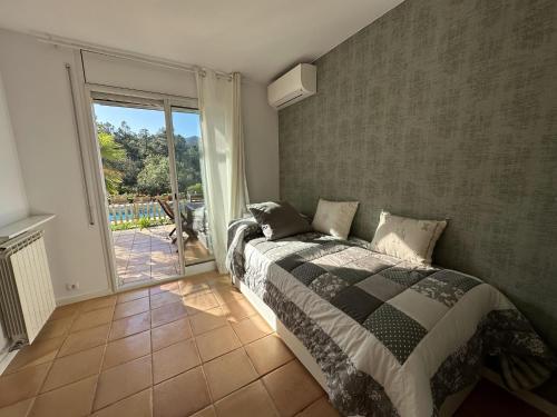 圣塔克里斯蒂纳阿鲁Villa Glamour的一间卧室设有一张床和一个滑动玻璃门