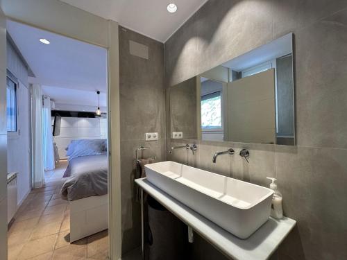 圣塔克里斯蒂纳阿鲁Villa Glamour的一间带水槽的浴室和一张位于客房内的床