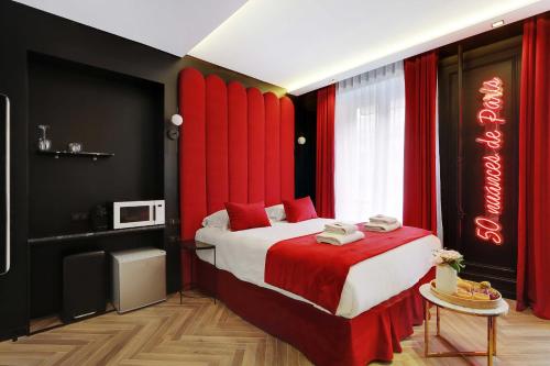 巴黎Couples Getaway Unit with Jacuzzi - City Center的一间卧室配有一张带红色窗帘的大床