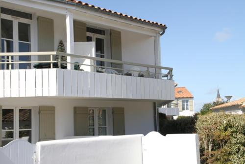 滨海拉库阿尔德Appartement en duplex avec balcon, 5 minutes plage et centre village的前面有白色围栏的白色房子