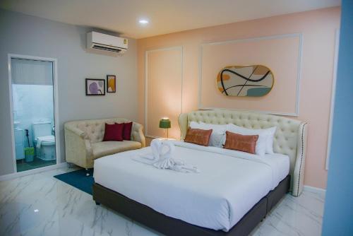 洛坤府JB Grand Resort的卧室配有一张白色大床和一把椅子