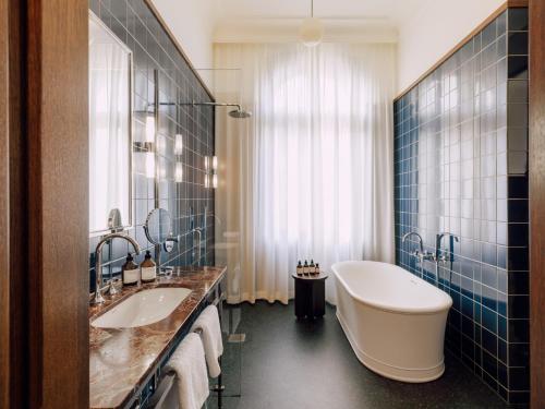 柏林Boutique Hotel Château Royal的浴室配有两个盥洗盆和浴缸。