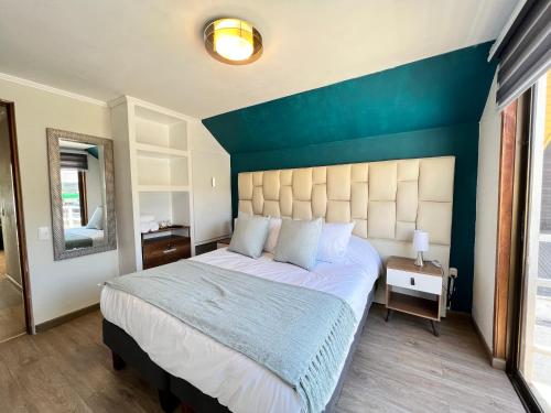 维纳德马Spazios Apart Hotel Reñaca的一间卧室设有一张蓝色墙壁的大床