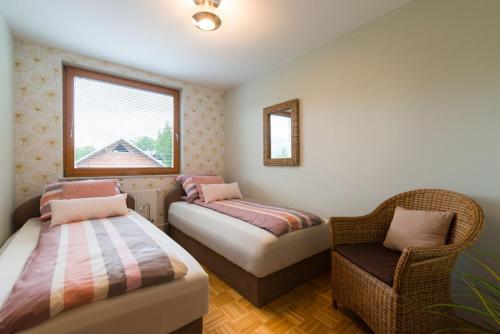 RibnoSava View 8的一间卧室设有两张床、一把椅子和一个窗户。